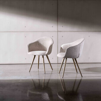 Distinguished Sovet Italia Dama chair with flexible polyurethane body upholstered in light textured textile and warm matte metal legs