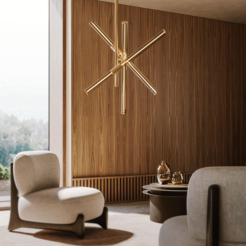 Brass chandelier with six arms hangs above walnut wood paneling, beige armchairs, and a dark brown rounded rectangular coffee table.
