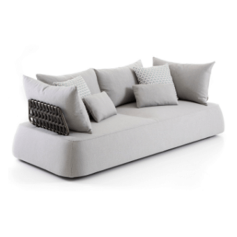 Light gray sofa with rounded cushions, arranged with textured pillows against a white backdrop in a studio setting.