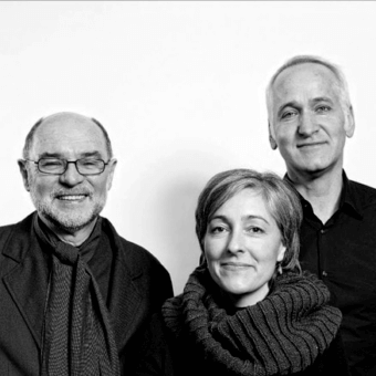 Black and white portrait of three people—man with glasses, woman with short hair, bald man—against a white backdrop, with text “maly hoffmann kahleyss”.