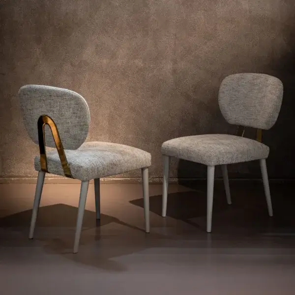 Armchairs, light gray textured fabric, curved back with brass accent, tapered metallic legs, Cassoni costantini pietro collection 2024.