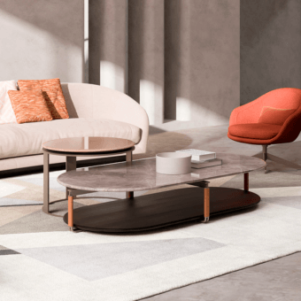 Nesting coffee tables with grey marble tops, dark brown wood frames, and orange metal accents, styled on a geometric rug.