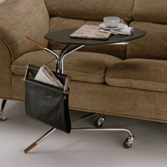 4Mariani side table, black lacquer, round tabletop, chrome articulated base with casters, black leather magazine rack, studio shot.