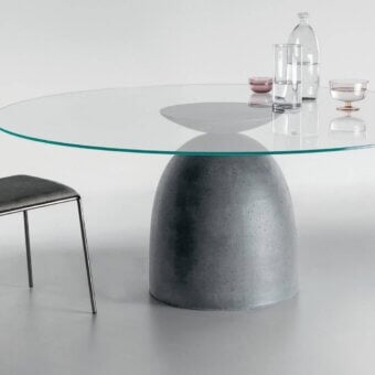 Harmonious Lago Janeiro table with transparent glass top and textured anthracite concrete base inspired by iconic shapes