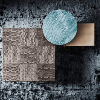 Coffee table, turquoise marble top, gold legs, styled with beige & bronze textured square surfaces on dark gray rug.