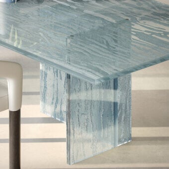Exceptional Reflex Laguna table with a light blue-grey glass top and base crafted with a unique molten texture