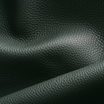 Dark green pebble-grain leather swatch with a diagonal fold, displaying a muted, deep tone and substantial texture with diffused lighting.