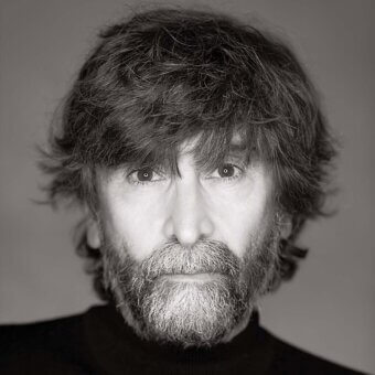 Marcello Ziliani portrait, black and white photograph, man with beard wearing black turtleneck, neutral gray background, direct gaze.