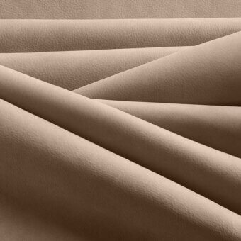 Cappuccino leather fabric stack, overlapping layers, subtle pebbled grain, matte finish, diffused studio lighting, tonal variations.