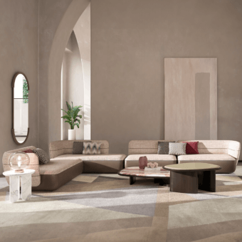 Beige L-shaped sectional sofa with modular cushions, paired with a pink and copper glass side table and geometric rug.