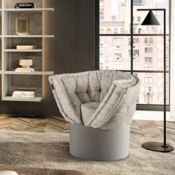 Distinguished Lago Huggy lounge chair with enveloping form draped in light gray Patchwork fabric and smooth matte cylindrical base
