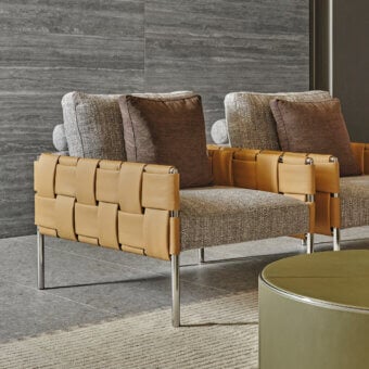 Elegant Turri Ratio lounge chair with woven leather structure and light dark brown flecked textile cushions with glossy metal legs