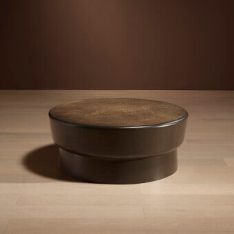 Bellavista Darius coffee table, dark brown matte finish, two-tiered rounded design with textured tabletop and cylindrical base on wood flooring.