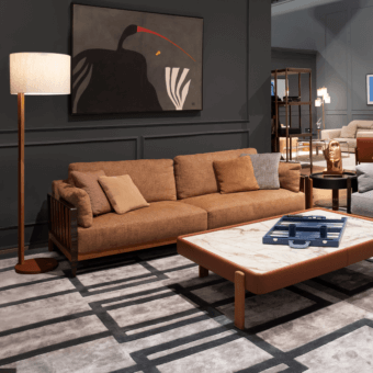 Daniela sofa, brown textured fabric, low profile with wood accents, centered with marble coffee table and floor lamp on patterned rug.