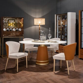 Superior Formitalia Iside table with white marble displaying grey veining and a leather-covered structure built with gold metal accents