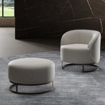 Distinguished Swan Italia Venus ottoman upholstered in subtly textured light gray fabric with a dark metal base and piping detail
