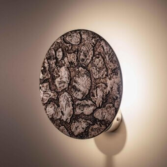 Distinguished Stillux Orbis wall lamp crafted in earthy stone with a rugged dark brown and light gray finish radiating soft light