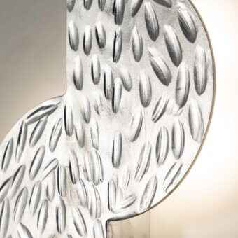 Exclusive Stillux Random wall lamp with an S-shape hammered metal frame and textured silver finish reflecting light from behind