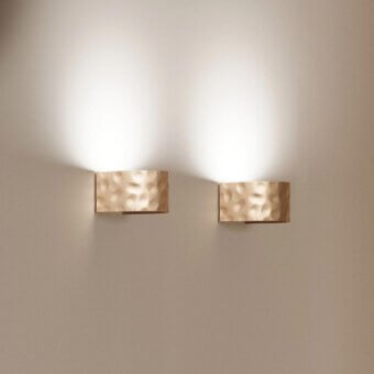 Sophisticated Stillux Shape wall lamp with hammered metal and rectangular form bathed in warm gold tone
