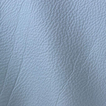 Light blue leather texture with a pebbled grain and matte finish, displaying diagonal creases and a subtly uneven, rounded surface pattern.