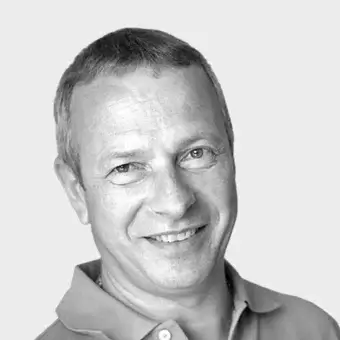 Man portrait, light green polo shirt, short hair, neutral gray background, soft lighting, visible skin texture, mature face, slight smile.