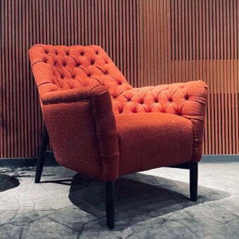 Superior Borzalino Eve Capitonnè lounge chair with warm orange-red textile and lacquered oak base