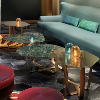 Elegant Borzalino Ground coffee table with an irregular amber meshed glass top and lacquered metal base crafted with a decorative cross design