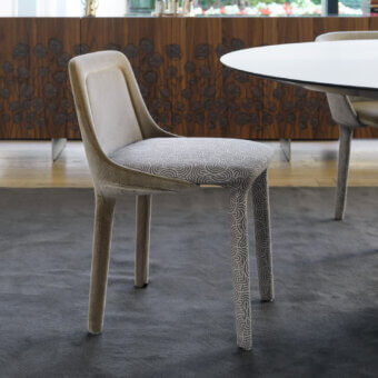 Distinguished Casamania Lepel chair upholstered in premium fabric with swirling gray patterns and a lighter beige spoon-like backrest finish