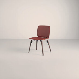 Frag iki chair, reddish-brown upholstery, rectangular back, angled matte black metal legs, dark brown wood accents, minimalist design.