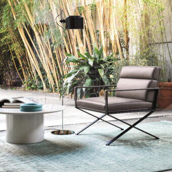Elegant Frag Sahrai lounge chair in medium gray-brown textile with a matte metal horizontally flipped base