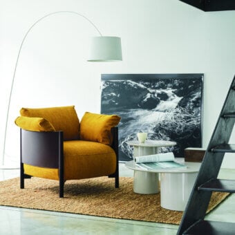 Sophisticated Frag Syren lounge chair with a dark brown tubular metal frame and voluminous mustard yellow textured textile cushions