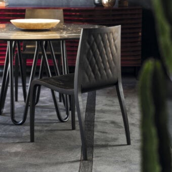 Superior Horm Ki chair crafted in Italy with solid wood legs, plywood seat and backrest, exhibiting quilted detailing and a dark tone