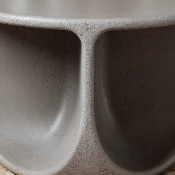 Exceptional Miniforms Pinto coffee table with curved openings and a matte concrete-like finish in varying shades of gray