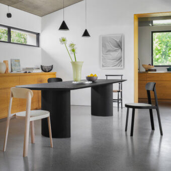 Exceptional Miniforms Plauto table crafted in Italy with a long racetrack tabletop and cylindrical pedestal bases in a dark matte finish