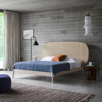 Distinguished Miniforms Shiko Wien bed with woven cane headboard and light-toned wood frame, crafted in blue quilted fabric