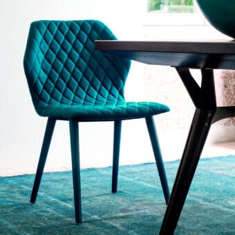 Captivating Bross Ava chair with teal fully upholstered shell and quilted diamond pattern built with lacquered metal legs