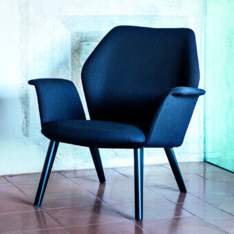 Superior Bross Ava lounge chair with dark textile upholstery and glossy black lacquer metal legs crafted in Italy