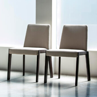 Exclusive Bross Bridget chair with neutral tan fabric and dark toned wood legs exhibiting a matte finish