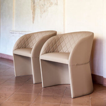 Exceptional Bross Hug armchair with quilted beige fabric upholstery, a high-end wood base and smooth finish