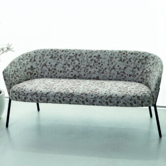 Distinguished Bross Wam sofa with curved silhouette and light gray patterned fabric upholstery supported by sleek black metal legs