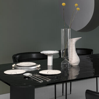 Superior Cierre1972 Riviera table with dark glass top exhibiting lighter patterns and minimalist metal frame