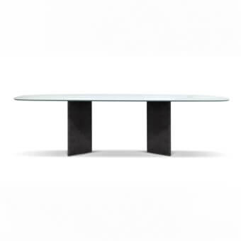 Glass table with dark gray metal bases, featuring an oval translucent green tabletop and angled wing-like supports, studio shot.