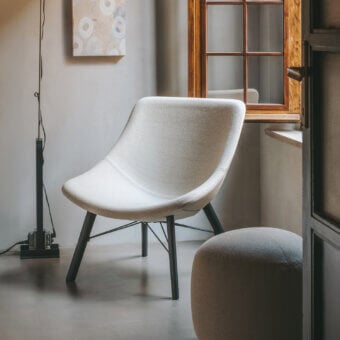 Lavish Lapalma Auki lounge chair with embracing lines upholstered in light textured textile and dark finished solid ash wood base