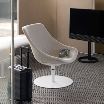 Elegant Lapalma Auki lounge chair with sinuous form upholstered in light textured textile with white powder-coated swivel base