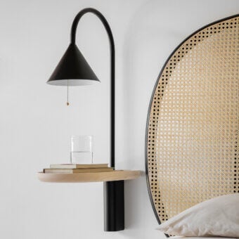 Elegant Miniforms Ozz wall lamp in matte black metal crafted with a curved arm and conical shade including a wooden shelf