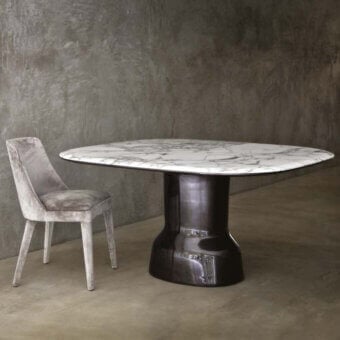 Distinguished Casa Casati Musa table with light marble and dark trim, built with a glossy, lacquered polyurethane resin pedestal base