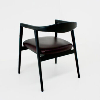 Sophisticated Casa Casati Romy armchair built with dark brownish-burgundy leather and sleek matt black natural ash wood frame