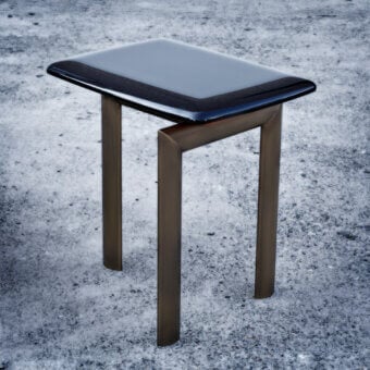 Elegant Casa Casati Sasso side table with glossy black lacquered wood and bronze-like metal supporting structure