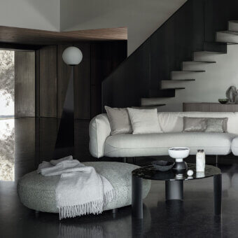 Elegant Cierre1972 Seed ottoman with heathered gray woven textile and fringed throw blanket offers contemporary comfort