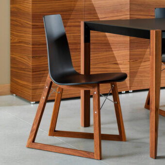 Distinguished Horm Ray chair with curved black lacquered plywood and a solid premium wood base crafted in Italy